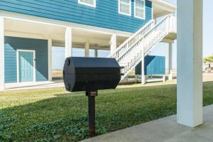 une boîte aux lettres dans l'herbe devant une maison dans l'établissement The Blue Haven - Cute Beach Bungalow With Easy Access to Sand and Gulf Waters!, à Surfside Beach 27 autres photos