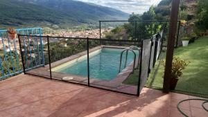 a swimming pool with a glass door on a balcony at Puerto de la Serrana in Jerte