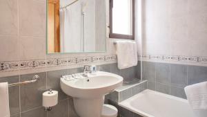 a bathroom with a sink and a toilet and a mirror at Estudios RH Sol in Benidorm