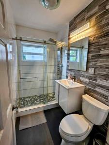 a bathroom with a shower and a toilet and a sink at Brickell Enclave Sunny Retreat with pool in Miami