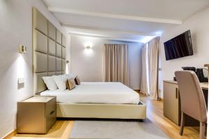 a hotel room with a bed and a desk at Relais Badoer in Rome