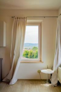 a window with a white curtain in a room at Belle Viste - Boutique Apartments in Bettolle