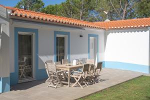 a table and chairs on the patio of a house at Monte dos Pinheiros in São Teotónio