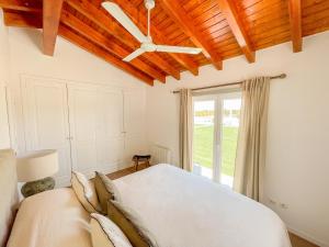 a bedroom with a bed and a ceiling fan at Monte dos Pinheiros in São Teotónio +41 photos