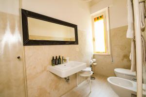 a white bathroom with a sink and a mirror at Belle Viste - Boutique Apartments in Bettolle