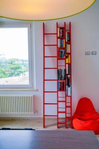 a red ladder book shelf in a room with a bed at Belle Viste - Boutique Apartments in Bettolle
