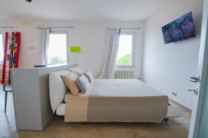 a bedroom with a bed and a desk and windows at Belle Viste - Boutique Apartments in Bettolle
