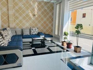 a living room with a blue couch and a glass floor at Hostal Alvasar in Copacabana