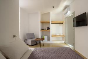 a bedroom with a bed and a chair and a television at Elia Pyrgos in Pyrgos