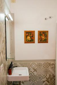 a bathroom with a sink and two pictures on the wall at Belle Viste - Boutique Apartments in Bettolle