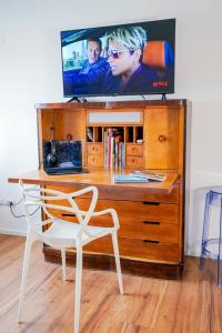 a television on top of a wooden dresser with a chair at Belle Viste - Boutique Apartments in Bettolle