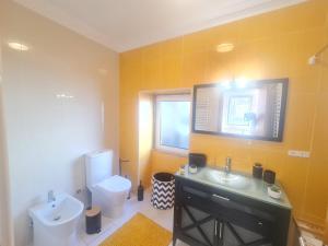 a bathroom with a sink and a toilet and a window at Casa Dos Passos in Guarda +15 photos