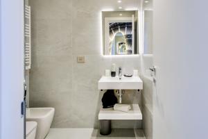 a white bathroom with a sink and a toilet at Relais Badoer in Rome