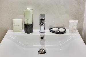 a white bathroom sink with candles and cosmetics on it at Relais Badoer in Rome