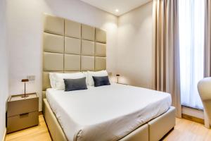 a bedroom with a large white bed and a window at Relais Badoer in Rome