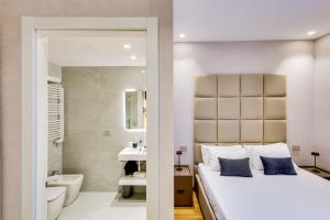 a bedroom with a king sized bed and a bathroom at Relais Badoer in Rome