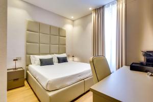 a bedroom with a white bed and a window at Relais Badoer in Rome