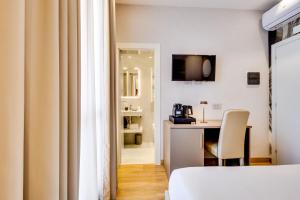 a room with a bed and a desk with a chair at Relais Badoer in Rome