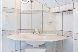 a bathroom with a white sink and a mirror at Ferienhaus Appelgarten in Blankenburg +23 photos