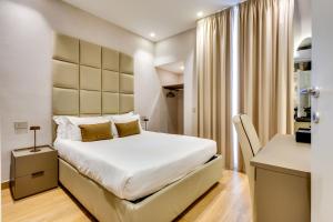 a bedroom with a large white bed and a desk at Relais Badoer in Rome
