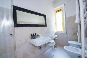 a white bathroom with a sink and a mirror at Belle Viste - Boutique Apartments in Bettolle