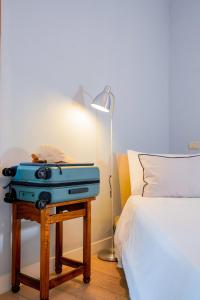 a blue suitcase sitting on a table next to a bed at Belle Viste - Boutique Apartments in Bettolle