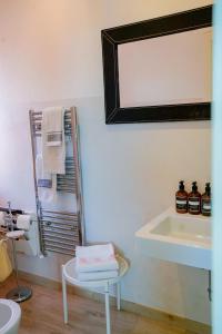 a bathroom with a sink and a mirror and a chair at Belle Viste - Boutique Apartments in Bettolle