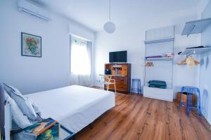 a bedroom with a white bed and a wooden floor at Belle Viste - Boutique Apartments in Bettolle