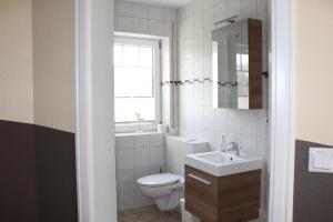 ein Badezimmer mit Toilette und Waschbecken und einem Fenster in der Unterkunft Ferienhaus Kiek Över in Prerow + 21 Fotos