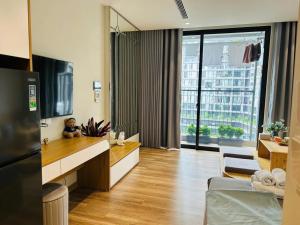 a living room with a television and a large window at Ben's Homestay Ecopark - Landmark L2 in HÆ°ng YÃªn