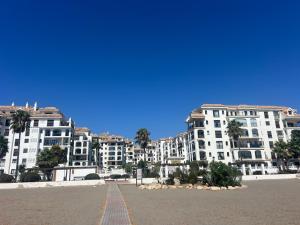 a row of white apartment buildings on a beach at Puerto De La Duquesa in Manilva