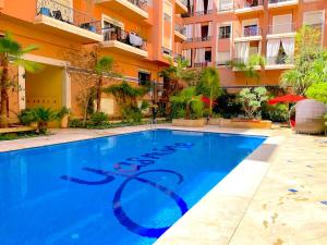 a swimming pool in front of a building at Yasmine Manjorelle Marrakech in Marrakech