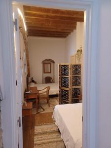 a bedroom with a bed and a desk in a room at Casa Maranaty in Vejer de la Frontera +15 photos