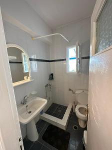 a white bathroom with a sink and a toilet at Family Apartment in Potamos Kythira in Potamós