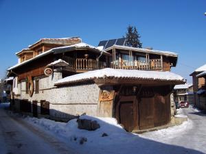 ein Holzhaus mit Schnee auf der Vorderseite in der Unterkunft Dedo Pene Inn in Bansko