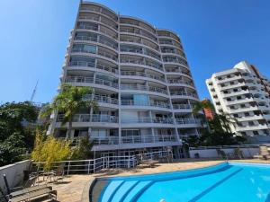 un gran edificio de apartamentos con piscina frente a él en Apto completo super confortável e moderno próximo Metro Vila Madalena, en São Paulo