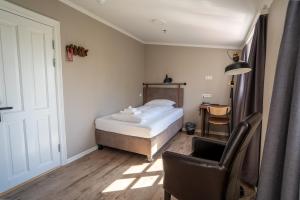 Un dormitorio con una cama, una silla y un escritorio. en Gistihúsið - Lake Hotel Egilsstadir, en Egilsstadir