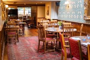a restaurant with tables and chairs in a room at The Red Lion Hotel in Hillingdon