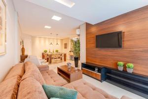 邦比尼亚斯Espetacular Apartamento em Condomínio com Piscina e Spa - Boulevard Bombinhas的客厅配有大沙发和平面电视