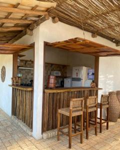 a kitchen with a counter with chairs and a table at Casa Monã in Maceio