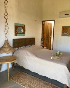 a bedroom with a bed and a table and a window at Casa Monã in Maceio