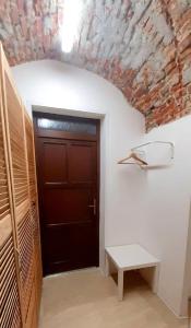 una puerta en una habitación con una pared de ladrillo en Jonas Old Town Apartment, en Košice