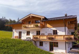 a house with a balcony on a hill at Ferienwohnung Hirnsberglehen in Bischofswiesen