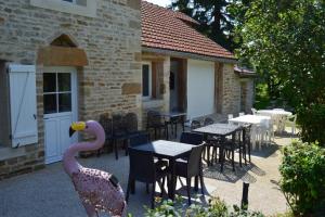 eine Außenterrasse mit Tischen und Stühlen sowie ein Gebäude in der Unterkunft Le Moulin au Fil de l'Eau in Verseilles-le-Bas + 8 Fotos