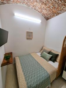 Un dormitorio con una cama y una pared de ladrillo. en Jonas Old Town Apartment, en Košice