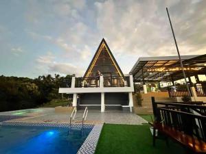 a man standing on the balcony of a house with a pool at Casa Olivia in Tuy