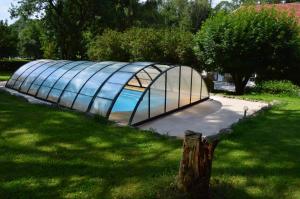 ein Gewächshaus aus Glas auf einem Grasfeld in der Unterkunft Le Moulin au Fil de l'Eau in Verseilles-le-Bas