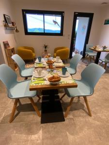 a dining room with a table and chairs with food on it at CHAMBRES D'HOTES Chez Nicole et Christian in Villaz