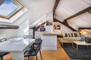 eine Küche und ein Wohnzimmer mit Tisch und Stühlen in der Unterkunft Marais Rooftop Apartment in Paris