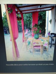 a table with pink curtains and a table with a doll at Entre mer et cevennes in Boisseron +9 photos